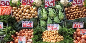 display of fresh vegetables in an open air food market with price tags