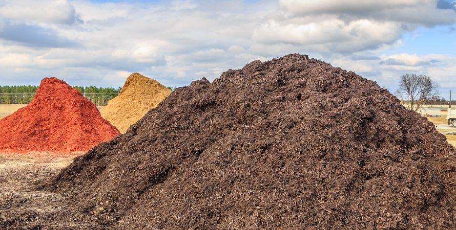 three heaps of red, black and brown sawdust and compost