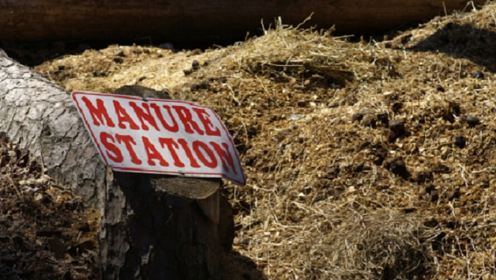 A pile of well rotten compost with a manure station signage