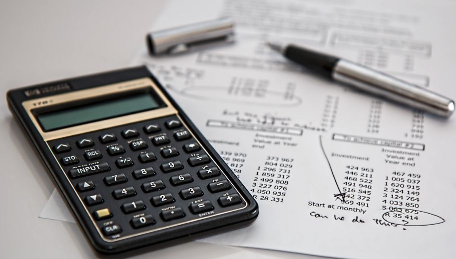 Record keeping; a picture showing a calculator on top of a financial statement and a pen. 