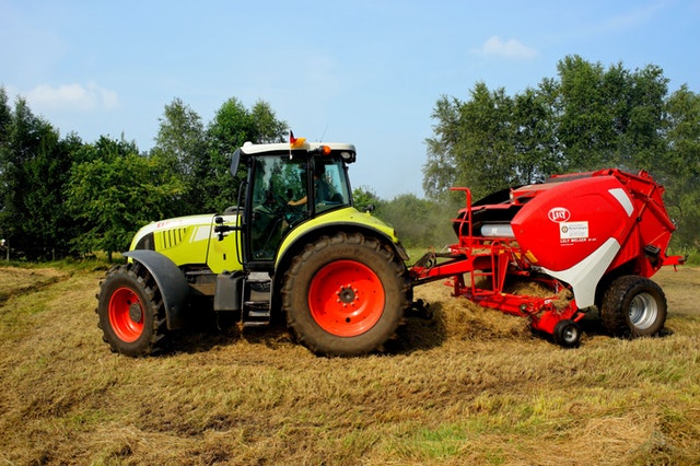 A picture of  a tractor pulling a hay making machine