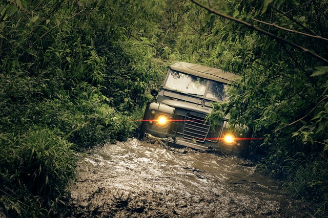 a landrover vehicle on a flood road in a forest