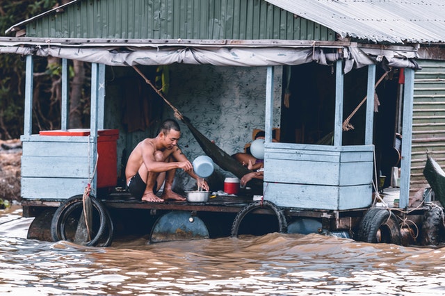 fisherman fetching water from a flooded river