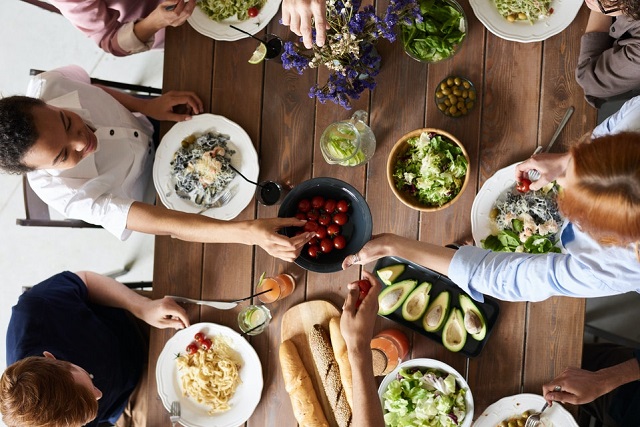 A group of people dining on various vegetable meals