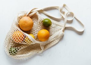 ripe orange fruits placed on a white knitted bag