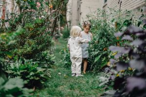 children on a backyard vegetable garden