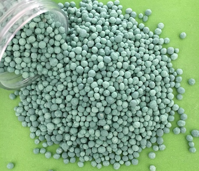 lime green granulated fertilizer from a clear container