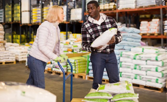 a black man and a white woman buying farm inputs from a shop