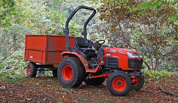 small red Kubota tractor attached to a trailert