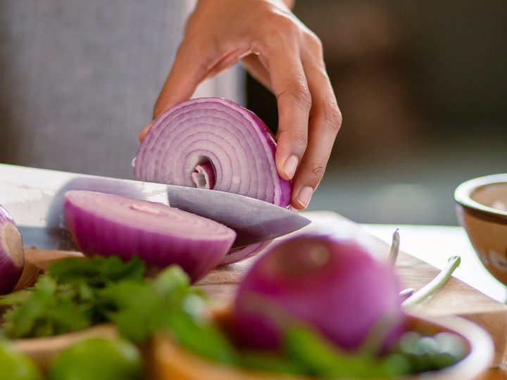 a-person-slicing-an-onion