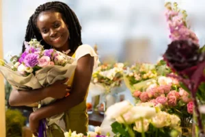 Cute dark-skinned girl holding big luxury flowers