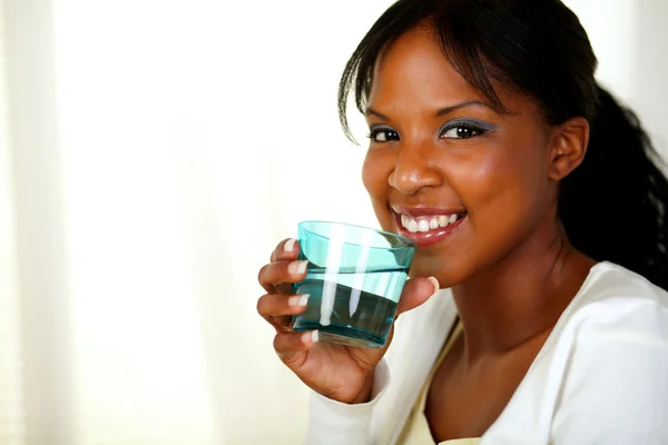 Black woman in white t-shirt drinking water