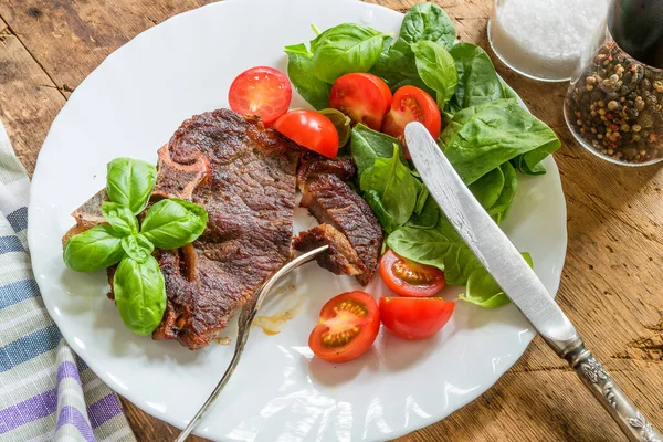 Delicious fried steak with fresh bright salad in a white plate
